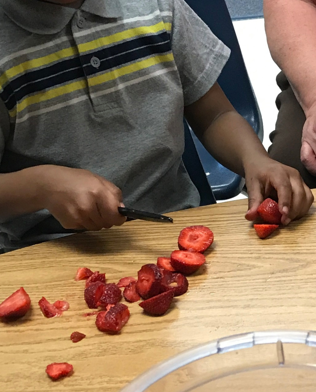 little kid cutting strawberries