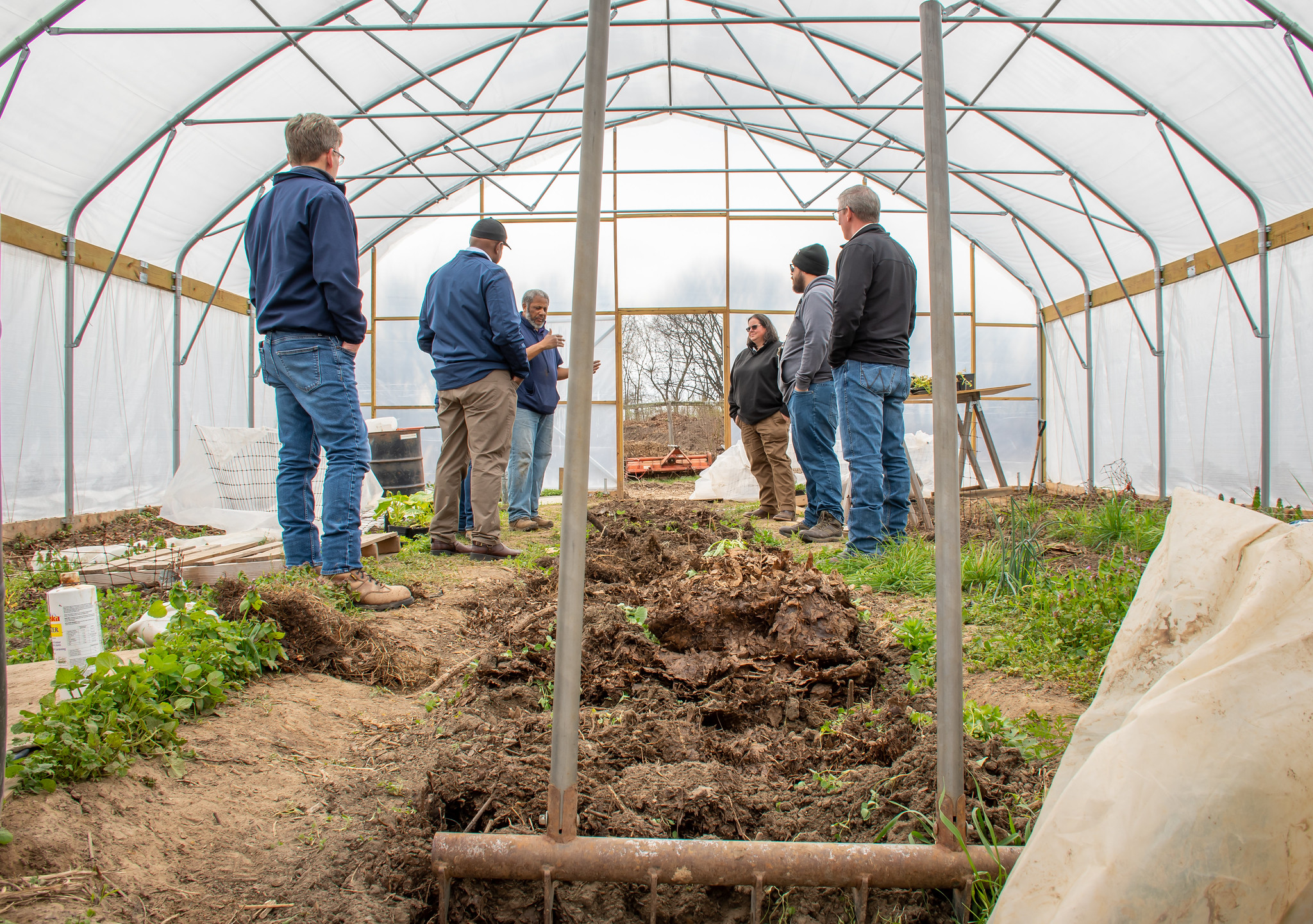 Farmers gathered in a hoop tunnel 