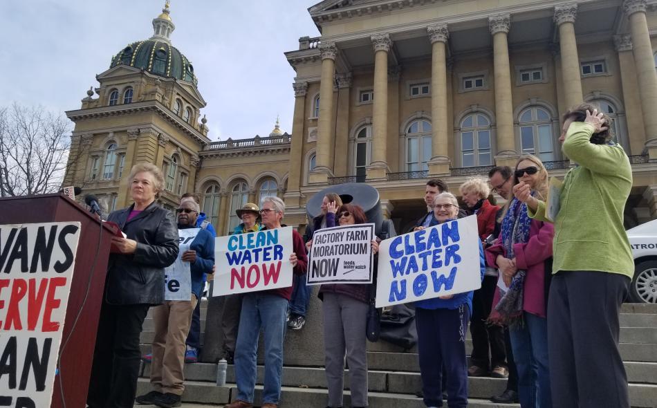 A crowd of anti factory farm advocates speaking outside the Iowa state capitol