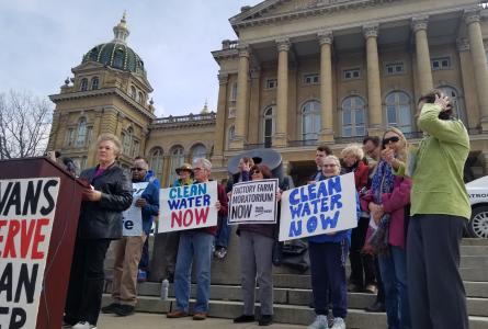 A crowd of anti factory farm advocates speaking outside the Iowa state capitol